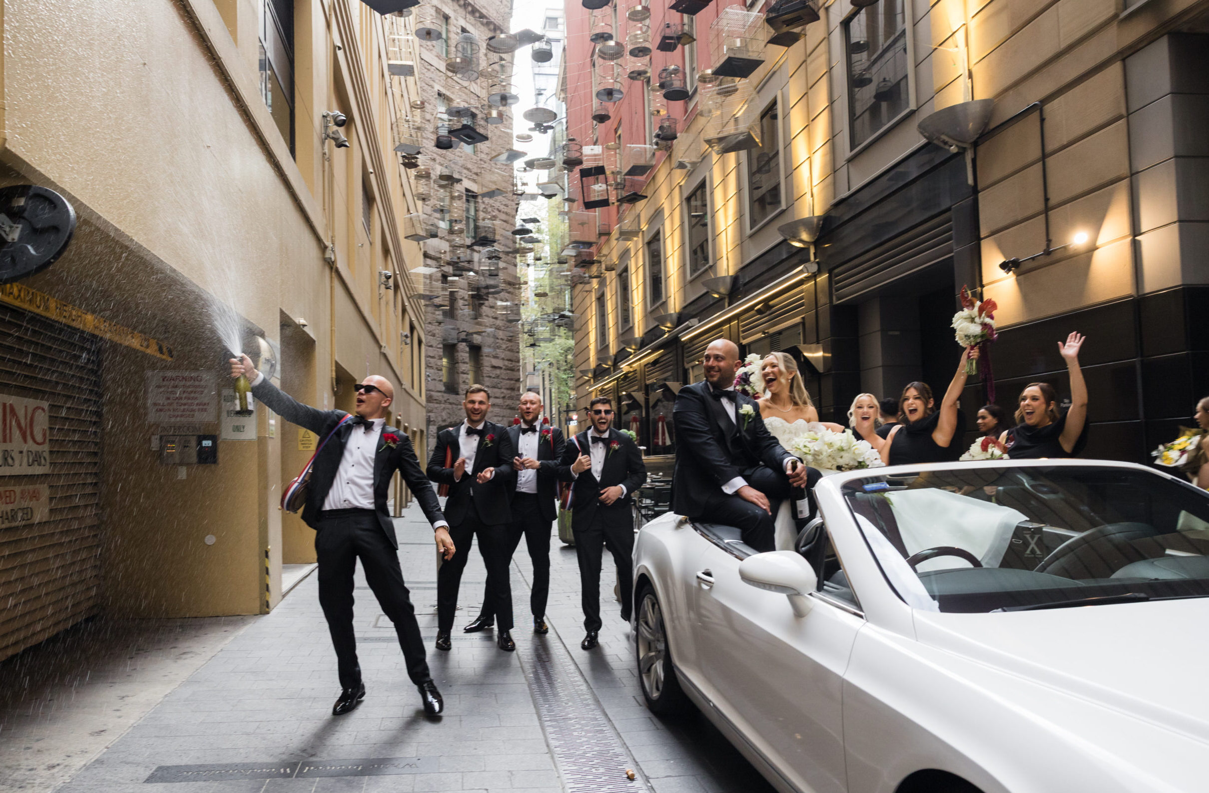 Adam and Alexandra with their bridal party during a champagne laneway moment in Sydney